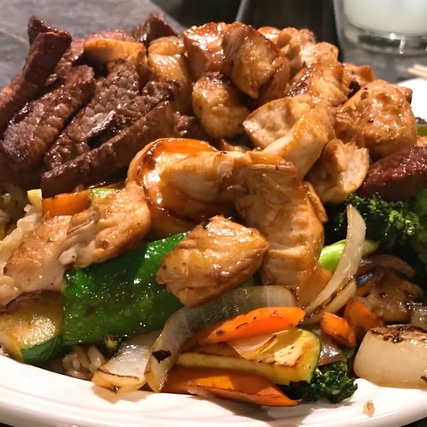 A close-up of a Kabuto hibachi plate with steak, chicken, and mixed vegetables.