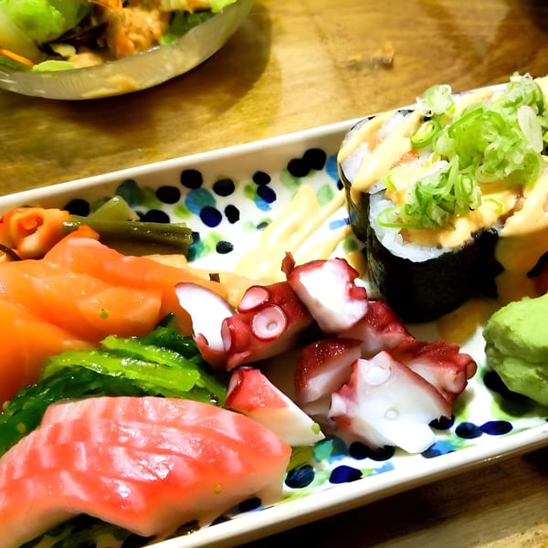 A colorful platter of Kabuto Japanese sushi, sashimi, octopus, and seaweed salad with wasabi.